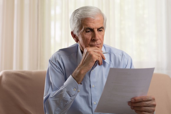 Senior man holding a sheet of paper