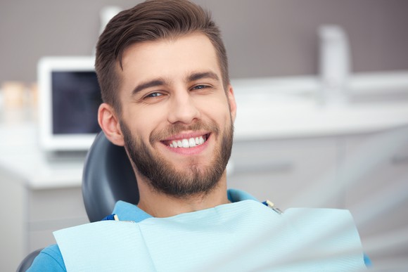 Man sitting in a dentist's chair, smiling.