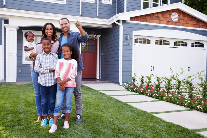 Family standing in front of new home.