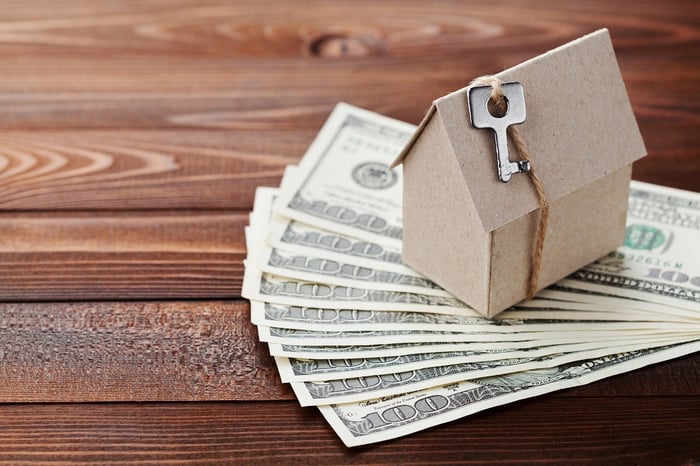 Cardboard house on top of $100 bills