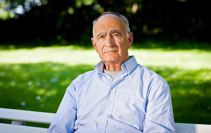 Somber senior man sitting on a bench