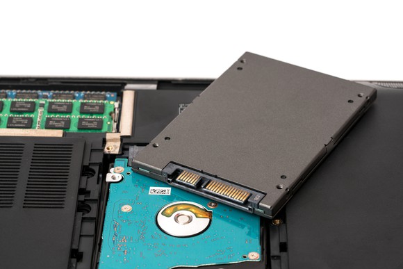 A SSD drive being removed from a laptop.