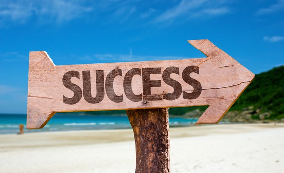arrow-shaped sign by a beach, with "success" written on it