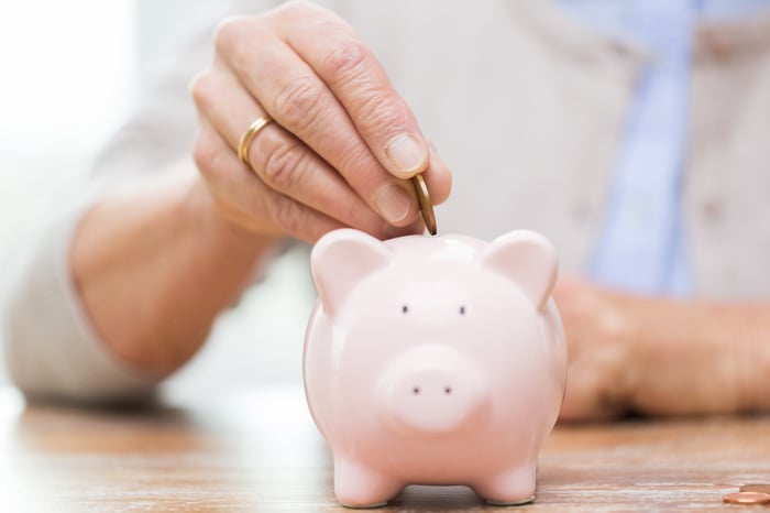 Putting a coin into a piggy bank