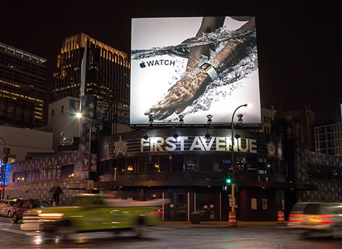 A billboard with an Apple Watch ad at a busy intersection