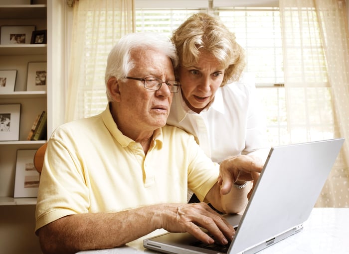 An elderly married couple reviewing their Medicare options on their laptop.