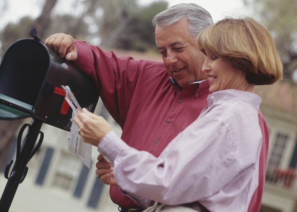 Middle-aged couple checking mail at a mailbox