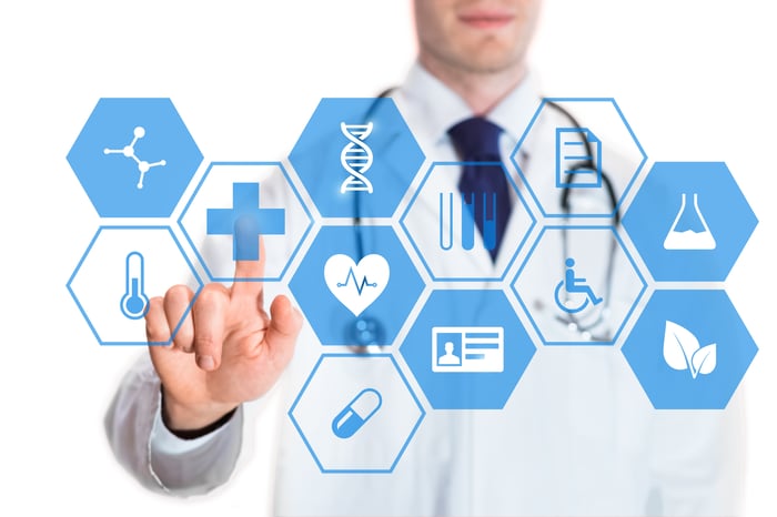 Medical doctor touching virtual interface button of healthcare application.