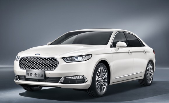The Ford Taurus as sold in China, a large white four-door sedan with Chinese license plates that shares styling cues with Ford's Fusion and Focus.