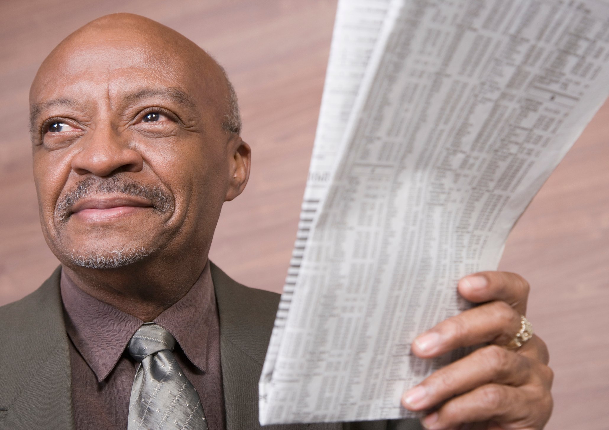 Senior businessman holding newspaper with stock listings