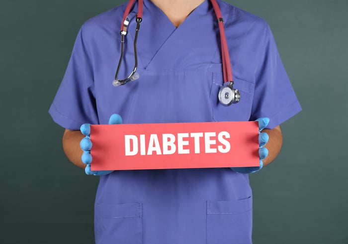 Healthcare provider holding a sign that says diabetes