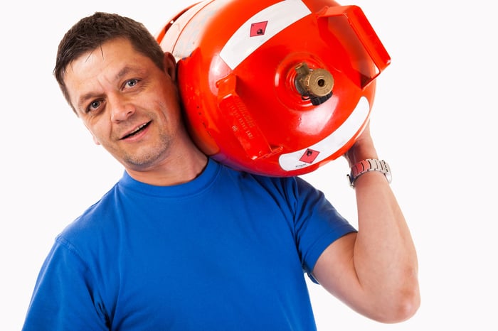 A man with a propane canister on his shoulder