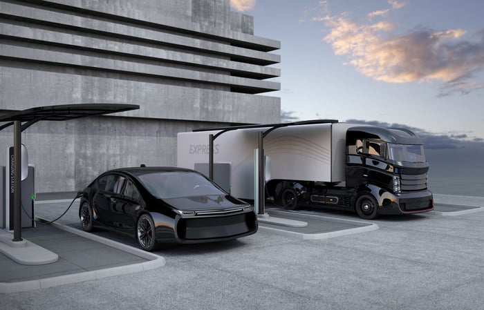 An electric car and electric heavy truck plugged in for charging.