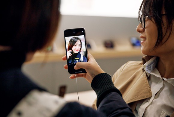 Chinese women using iPhone X in an Apple Store