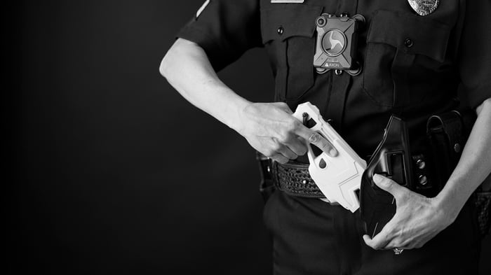 Police officer removing a Taser device from its holster