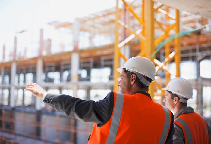 Construction workers at a steel building construction site. 