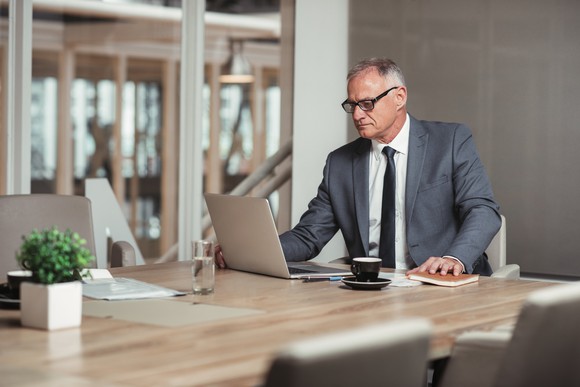 Older man in a suit working on a computer