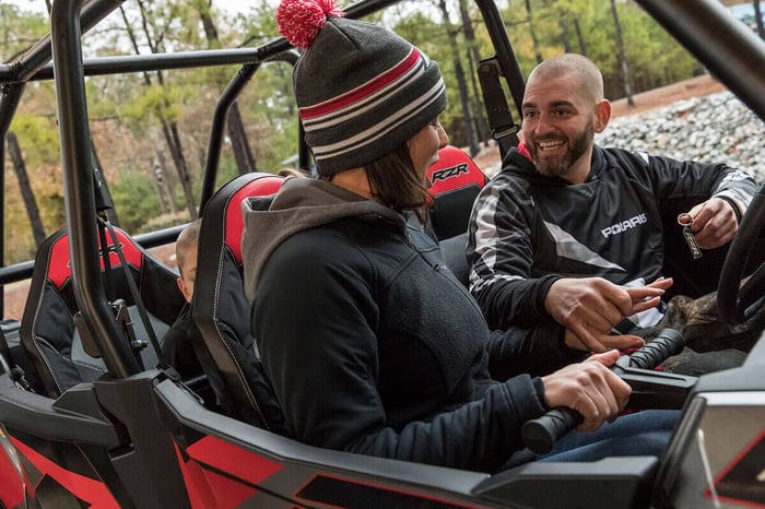 Family riding in side-by-side off-road vehicle