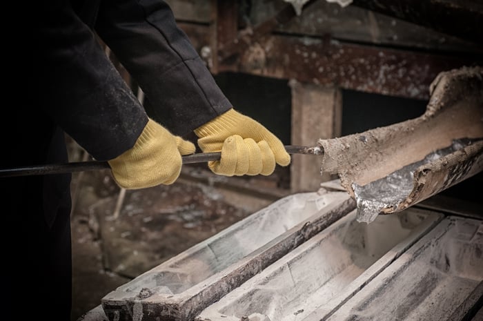 A person pouring molten aluminum into a mold