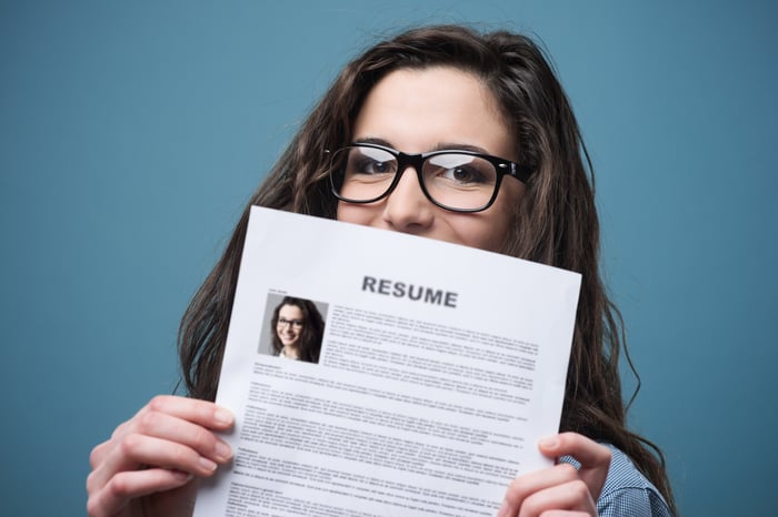 Young woman holding up a resume