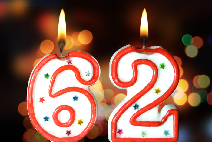 Two lit birthday candles -- one is the number 6 and the the number 2