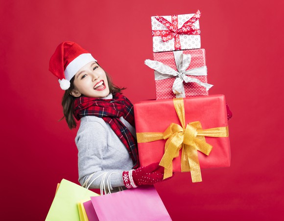 A woman holding a stack of presents