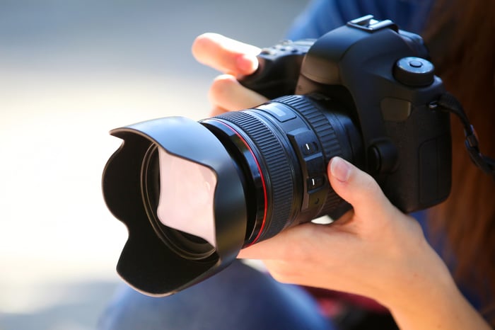 A photographer holding a full-frame camera. 