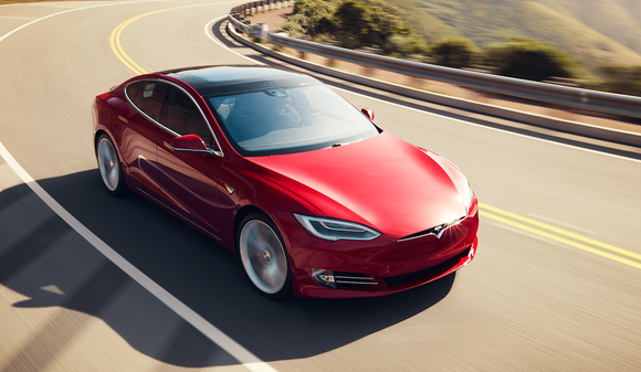 Red Tesla Model S car on road.
