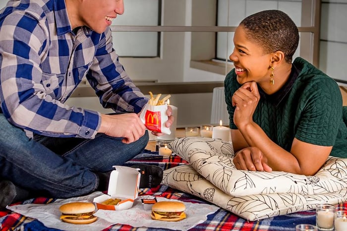 Two people eating McDonald's food. 