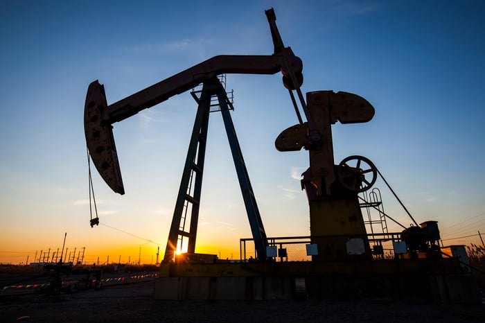 A beam of light shining through an oil pump at sunset.