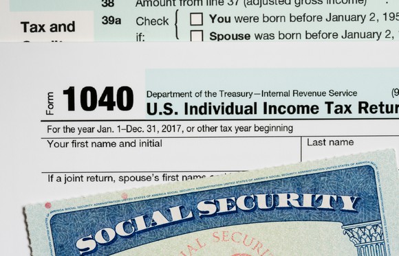 1040 tax form, stacked between tax instructions and a Social Security card.