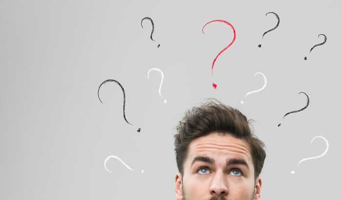 confused-looking man with question marks above his head