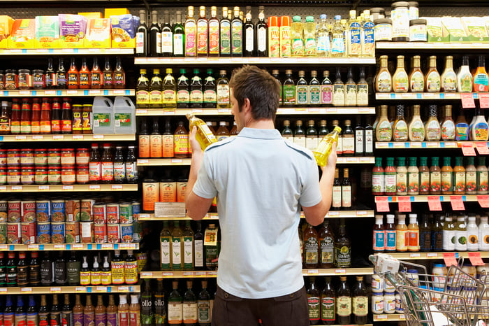 Man in grocery retail store deciding between two things to buy