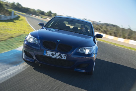 A dark blue BMW M5 on a European testing track.