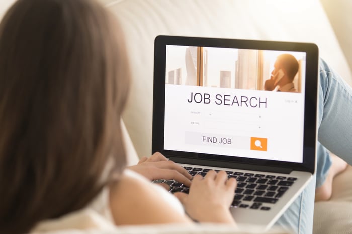 Woman at laptop with job search on screen