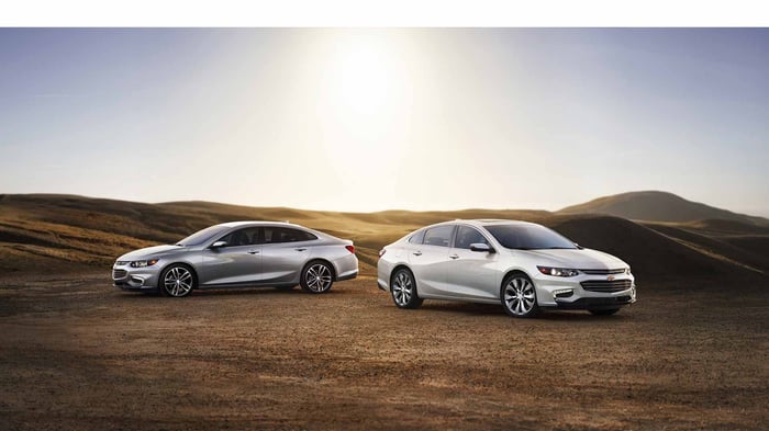 Two Chevy Malibu cars in a desert setting