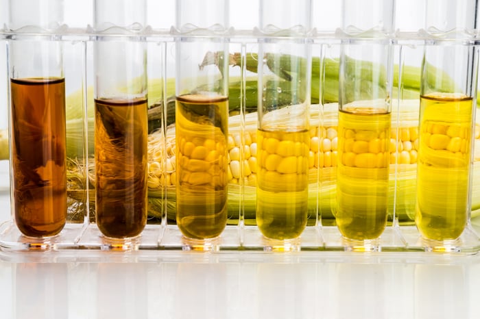 Biofuels in test tubes with a ear of corn in the background.