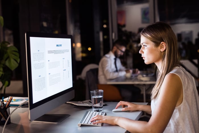 Woman at a computer in a dark office