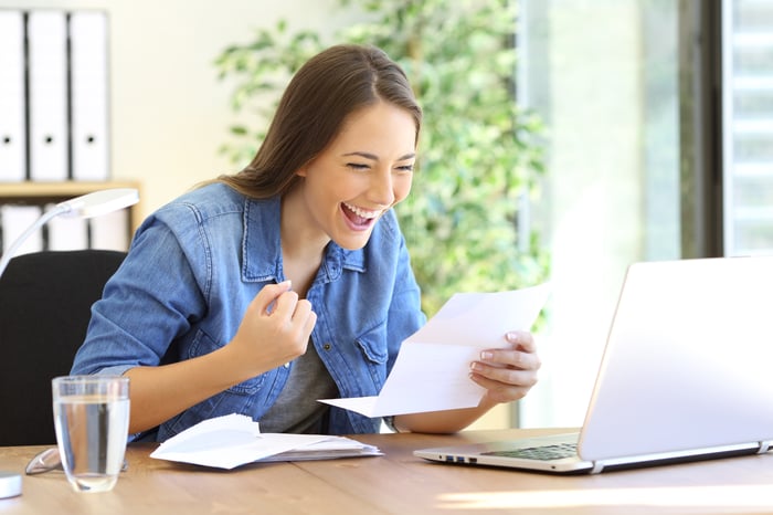 Young woman with excited expression reading a document