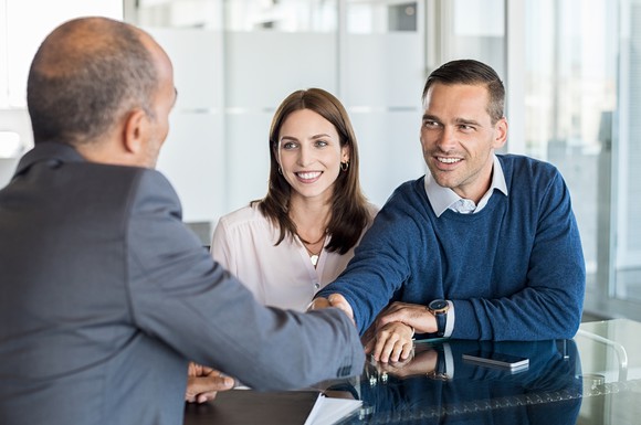 A couple meeting with man in a suit.