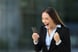 AG excited businesswoman with smartphone