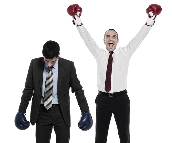 Two men in business suits and boxing gloves.