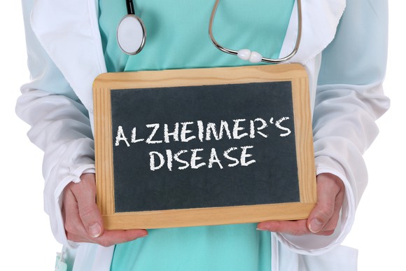 Physician holding small chalkboard with "Alzheimer's disease" written on it