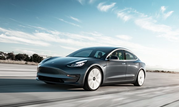 A silver Tesla Model 3, a sleek compact luxury sedan