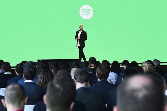 Daniel Ek on stage with a green background and the Spotify logo