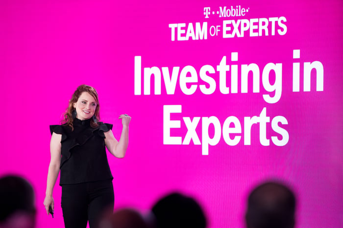 T-Mobile Executive Vice President of Customer Care Callie Field standing in front of a screen that says Investing in Experts.