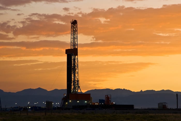 A drilling rig in Wyoming with a sunset in the background.