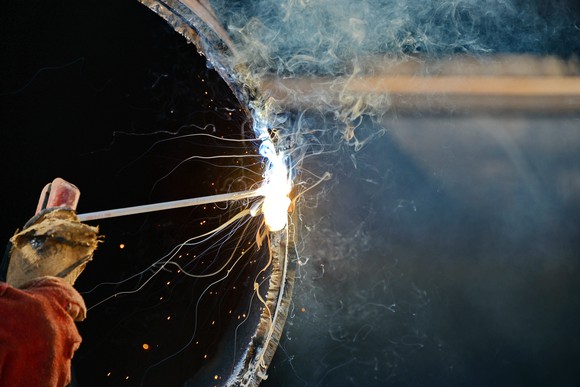 A welder working on a large pipe.