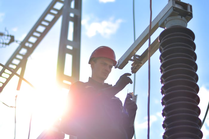 A man standing in front of high voltage electrical equipment