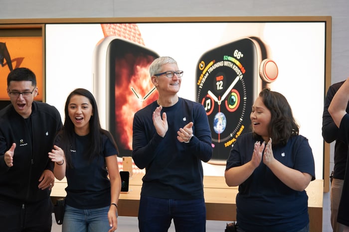 Tim Cook with two Apple employees to his right and one to his left.